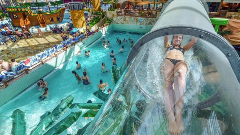 Frau rutscht mit Freude die Wasserrutsche im Aquamagis Plettenberg hinunter.