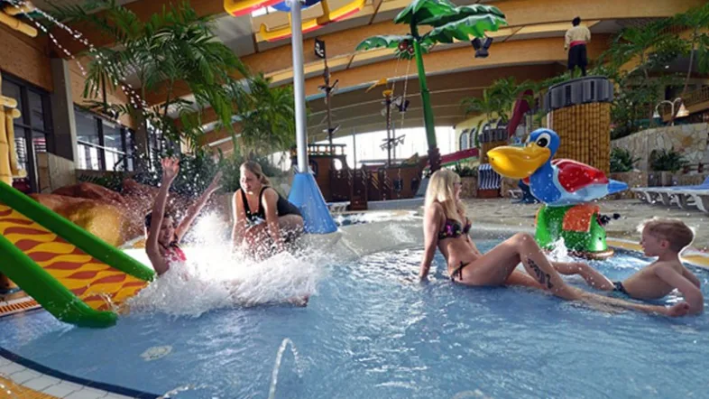 Menschen plantschen fröhlich im Schwimmbecken des Aquamagis Plettenberg.