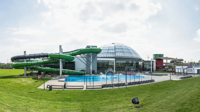 Blick auf den Außenpool im Aquapark Oberhausen mit klarem Wasser und Liegeflächen im Sonnenschein.