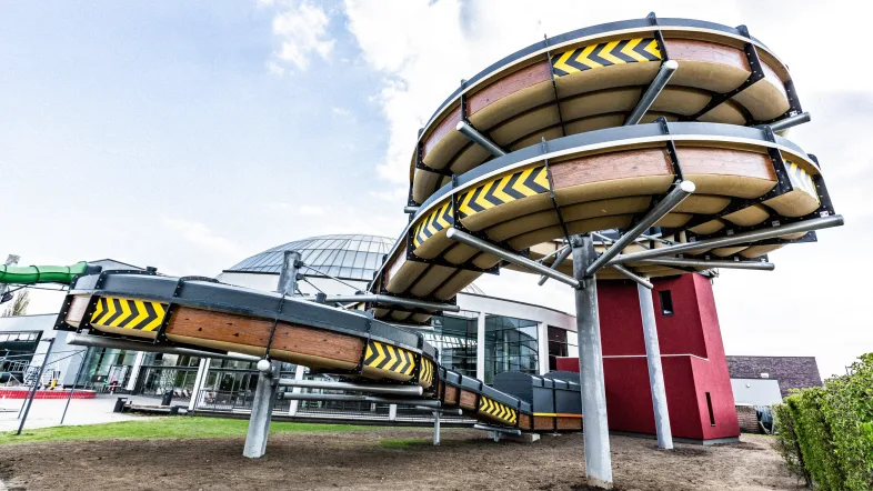 Außenansicht der Knappenrutsche im Aquapark Oberhausen mit markanter roter Rutschbahn und blauer Umrandung.