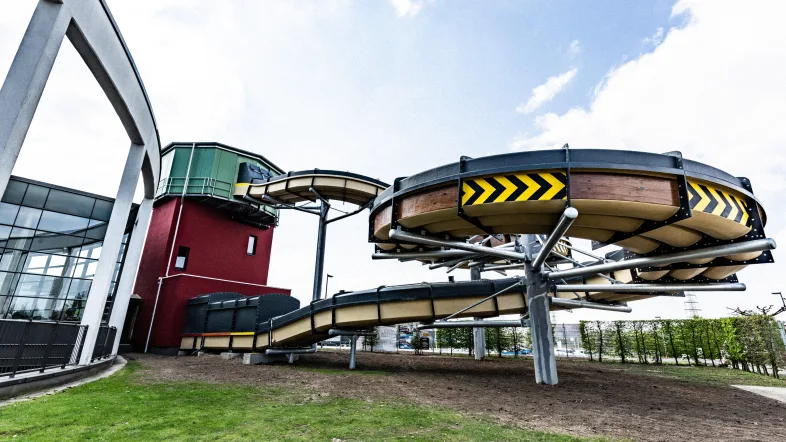 Außenansicht der Knappenrutsche im Aquapark Oberhausen mit markanter roter Rutschbahn und blauer Umrandung.