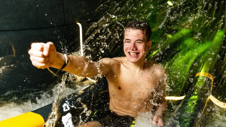 Mann rutscht mit Spaß die Wasserrutsche im Aquapark Oberhausen hinunter.