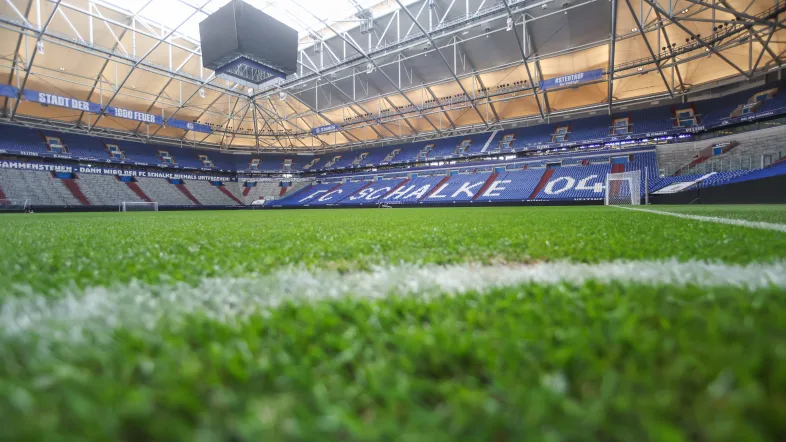Grüne Wiese mit Blauer Tribühne aus Sicht des Rasens bei der Arena auf Schalke.