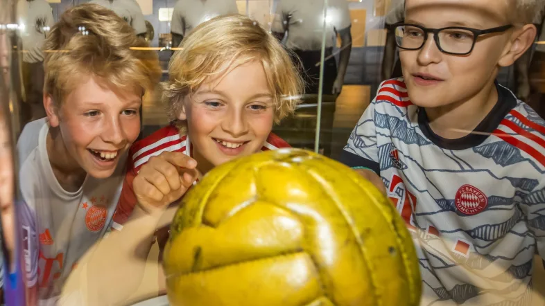 Kinder schauen sich Fußball in einer Vitrine im deutschen Fußballmuseum Dortmund an.