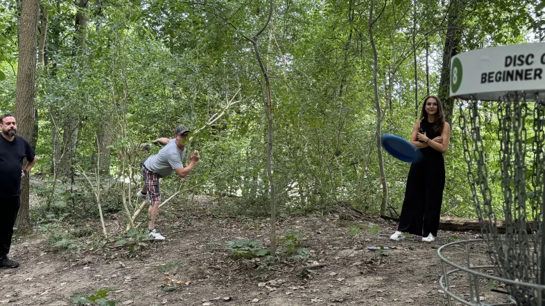 Mann wirft Frisbee beim Disc Golf im Wald in Dortmund.