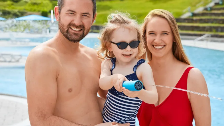 Familie steht gemeinsam am Beckenrand des Freibads Witten Annen und schaut in die Kamera.