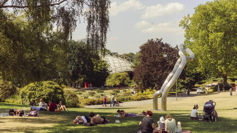 Menschen genießen ein Picknick im Grugapark Essen an einem sonnigen Tag.
