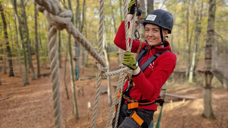 Frau hängt in eine Netz im Kletterwald Freischütz.