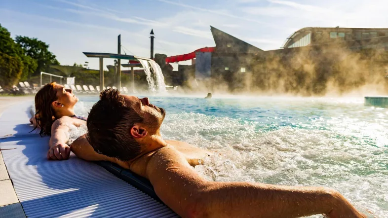 Paar entspannt gemeinsam im Wasser der Maximare Therme Hamm in freundlicher Umgebung.