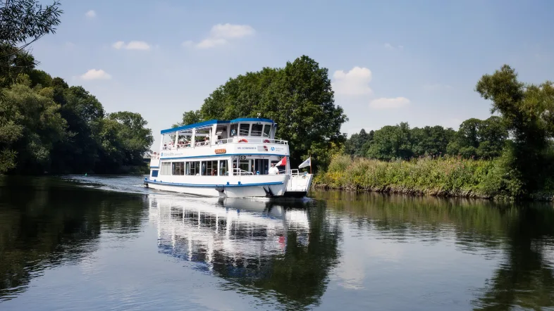 MS Schwalbe in Witten mit klarer Spiegelung im ruhigen Wasser unter blauem Himmel.