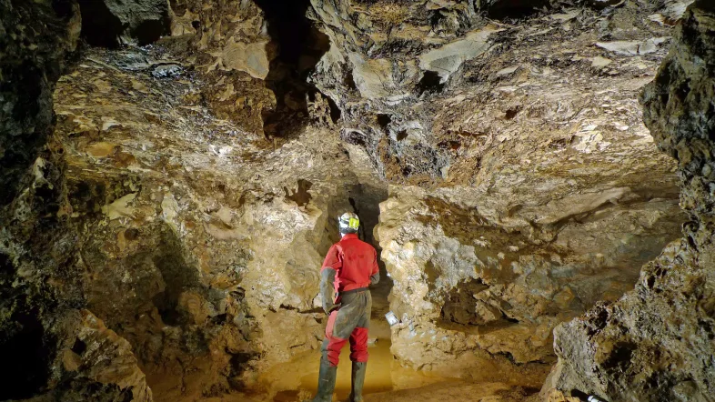 Mann steht in der Kluterthöhle Ennepetal zwischen beeindruckenden Felsformationen.