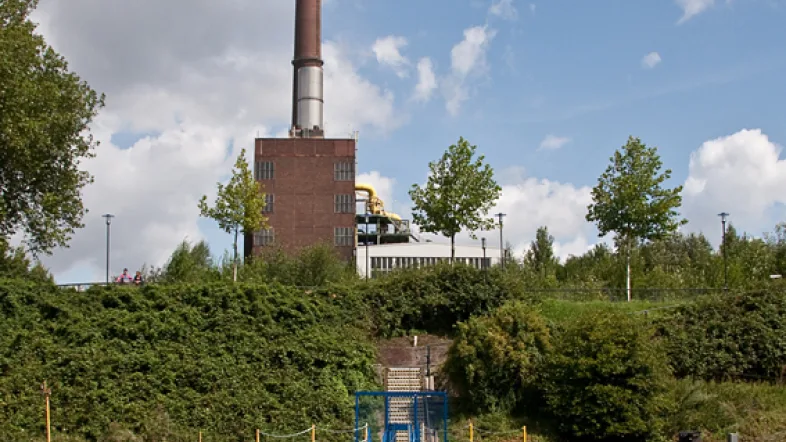 Personenschiff der Ruhrorter Schifffahrt fährt durch ein ruhiges Hafenbassin, umgeben von Kais und Lagerhäusern.