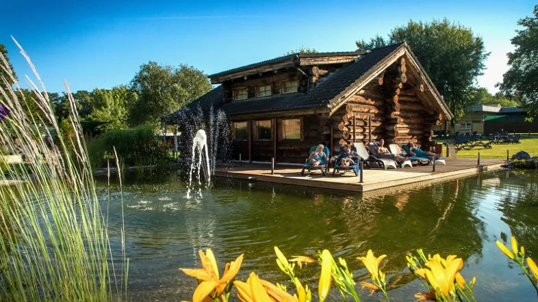 Außenbereich der Sauna im Solebad Wischlingen Dortmund mit Holzhütte und umgeben von grüner Natur.