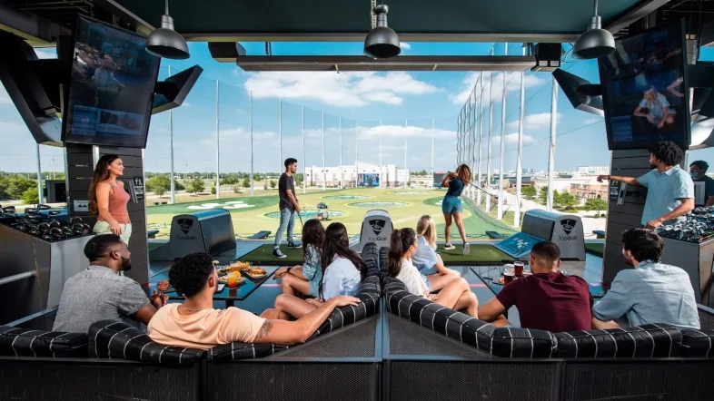 Gruppe von Freunden spielt zusammen bei Topgolf Oberhausen.