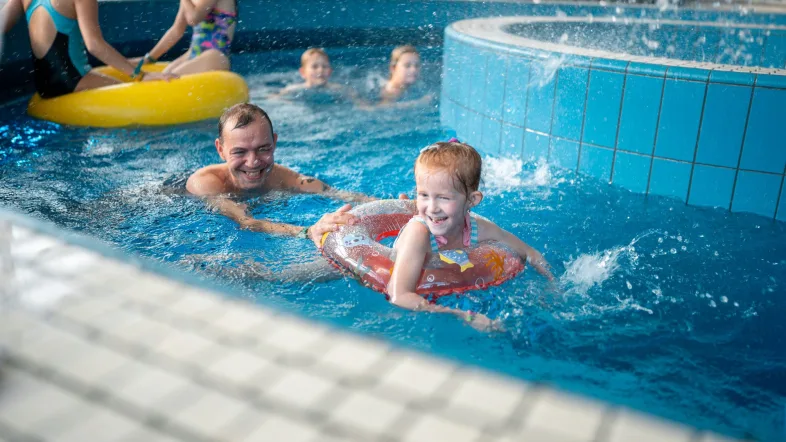 Vater und Tochter spielen fröhlich gemeinsam im Wasserbereich des Wananas Herne.