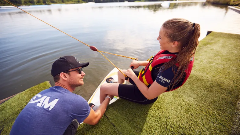 Wasserski-Instructor an der Anlage in Hamm gibt einer Frau Tipps und Anweisungen vor dem Start.