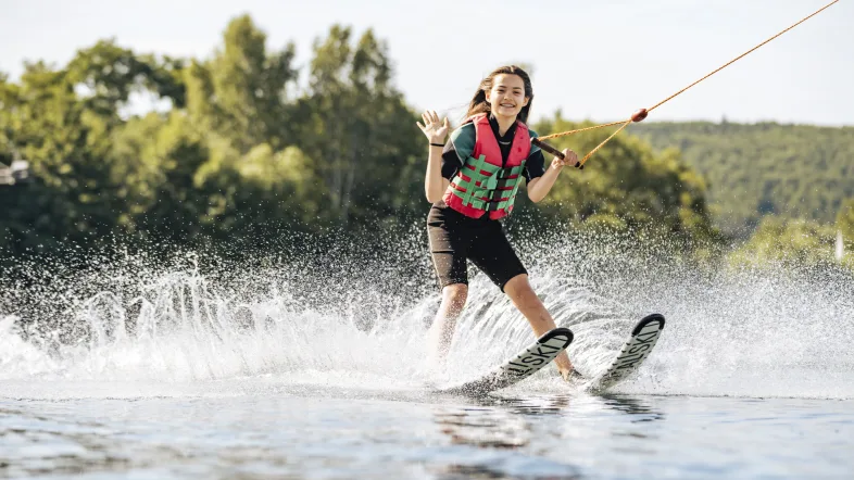 Ein Mädchen fährt konzentriert Wasserski auf der Anlage in Hamm und zieht eine Spur über das Wasser.